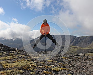 girl have fun on top of the mountain - hanging on a trekking stick