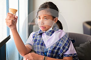 Girl have a hypersensitive teeth while eating ice-cream in the cafe after school