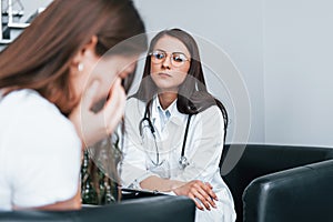 Girl have mental breakdown and crying. Young woman have a visit with female doctor in modern clinic