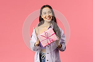 Girl have a present for you. Portrait of stylish pretty young asian female holding wrapped gift box and smiling at