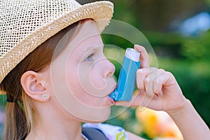 Girl having asthma using asthma inhaler for being healthy