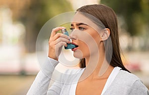 Girl Having Asthmatic Attack Using Inhaler Walking In City photo