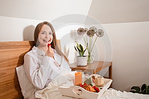 Girl having breakfast in bed on Sunday morning