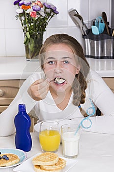 Girl having breakfast in kitchen