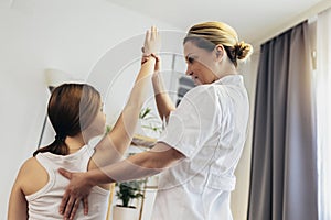 Girl having chiropractic back adjustment. Osteopathy, Physiotherapy, Kinesiology. Bad posture correction