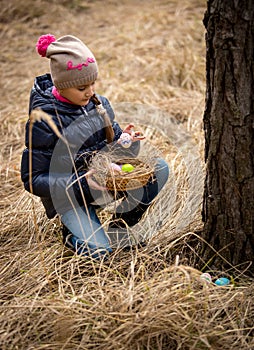 Girl having Easter egg hunt at forest