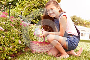 Girl Having Easter Egg Hunt In Garden