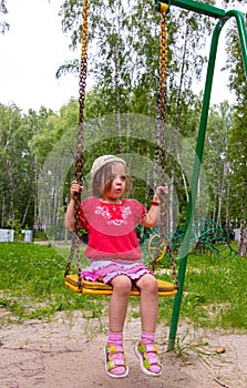 Girl having fun swinging on a swing at the playground