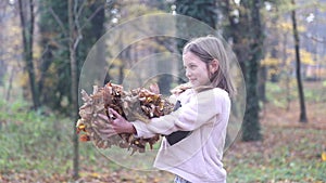 Girl having fun throwing leaves in the air