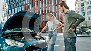 Girl having troubles with her auto, Man decided to help, Woman telling him about the failure while they are standing