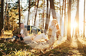 Girl is having a walk. Happy family of father, mother and little daughter is in the forest