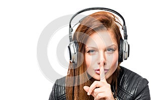 Girl in headphones asks keep quiet on a white background