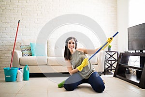 Girl with headphones and a broom