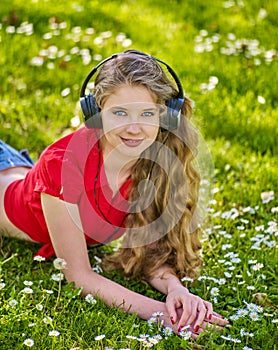 Girl in headphones catch rhythm music on green grass