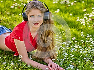 Girl in headphones catch rhythm music on green grass