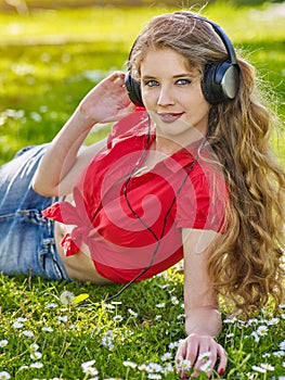 Girl in headphones catch rhythm music on green grass