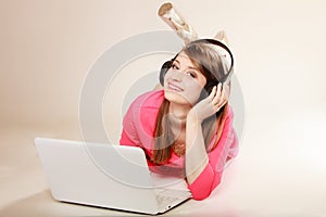 Girl with headphones and laptop listening to music