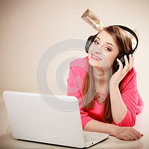 Girl with headphones and laptop listening to music