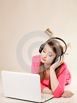 Girl with headphones and laptop listening to music