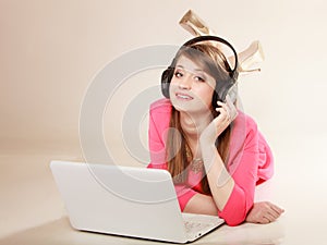 Girl with headphones and laptop listening to music