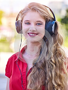 Girl in headphones listens crazy about mp3 music in city