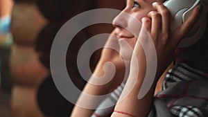 Girl in headphones listens to music closeup side