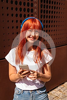 Girl with headphones looks at camera and smiles