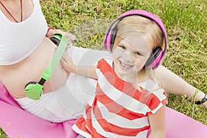 Girl with headphones and a pregnant mom