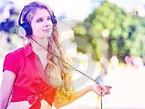 Girl in headphones and red shirt listens to mp3 music