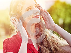 Girl in headphones and red shirt listens to mp3 music