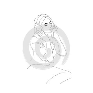 Girl in headphones sits listening to music on headphones.