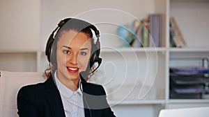 Girl with headset and laptop answering call in office