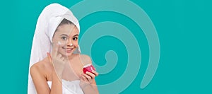 Girl with healthy skin, facial treatment, funny child in bath tower applying face cream, healthy skin. Cosmetics and