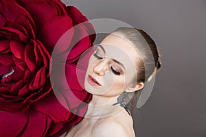 Girl with healthy skin relaxes after a Spa treatment with a red flower