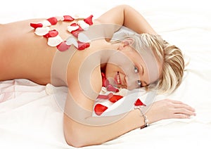 Girl with heart-shaped petals in massage salon