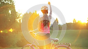 Girl in helmet on bicycle in park with city horizon