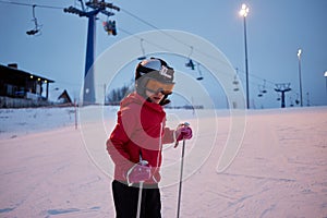 Girl in helmet with camera skiing on snowy slope photo