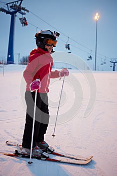 Girl in helmet with camera skiing on snowy slope photo