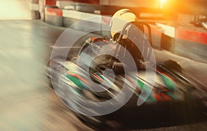 Girl in helmet driving kart on track