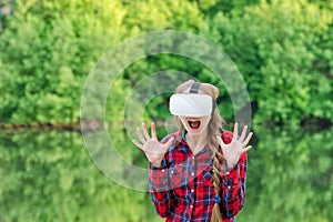 Girl in a helmet of virtual reality on a background of nature. Fright