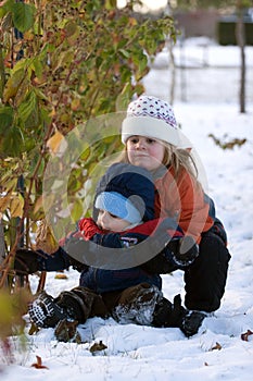 Girl helping brother in snow