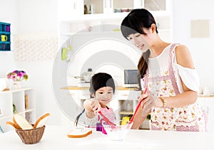girl helping her mother prepare food in the kitchen