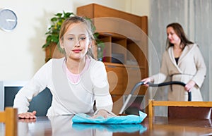 Girl helping mom to do cleaning