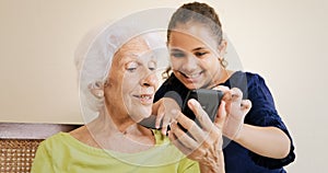 Girl Helps Grandmother Using Mobile Phone And Technology