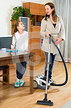 Girl helps mother to clean room