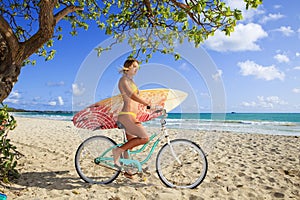 Girl on her bicycle with surfboard