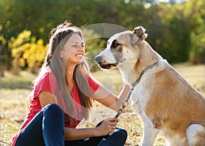 Girl with her Central asian shepherd dog in autumn sunny park