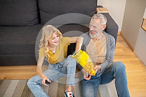 A girl and her dad sitting on the floor together