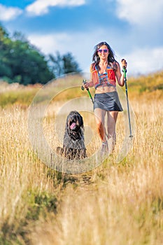 Girl with her dog on a Nordic walking trip