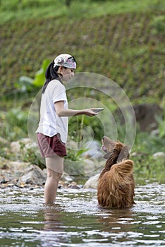 Girl and her dog playing in the river